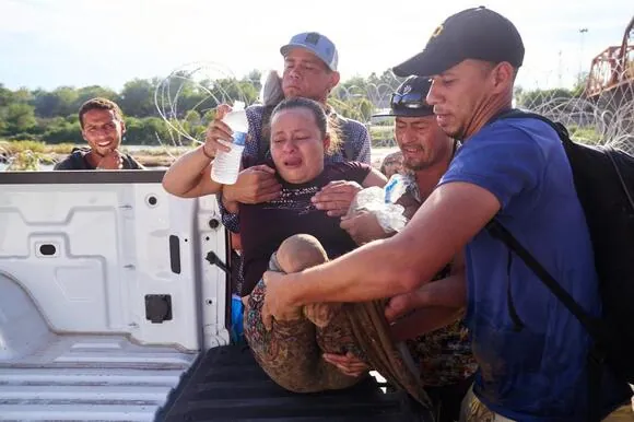 Honduran migrant Maria Argentina, an amputee, and daughter, Nathalie, 2, crossed the Rio Grande river from Mexico into the United States on Sunday.